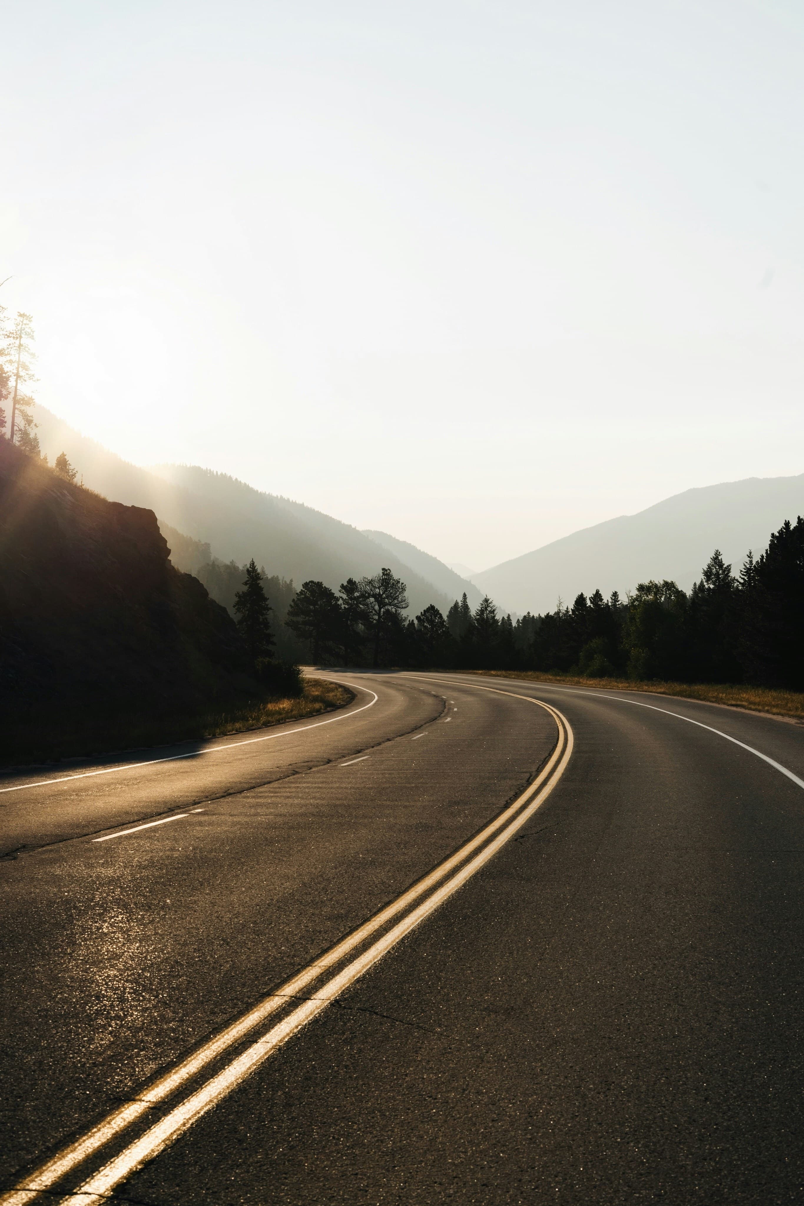 Empty road with mountains at sunset