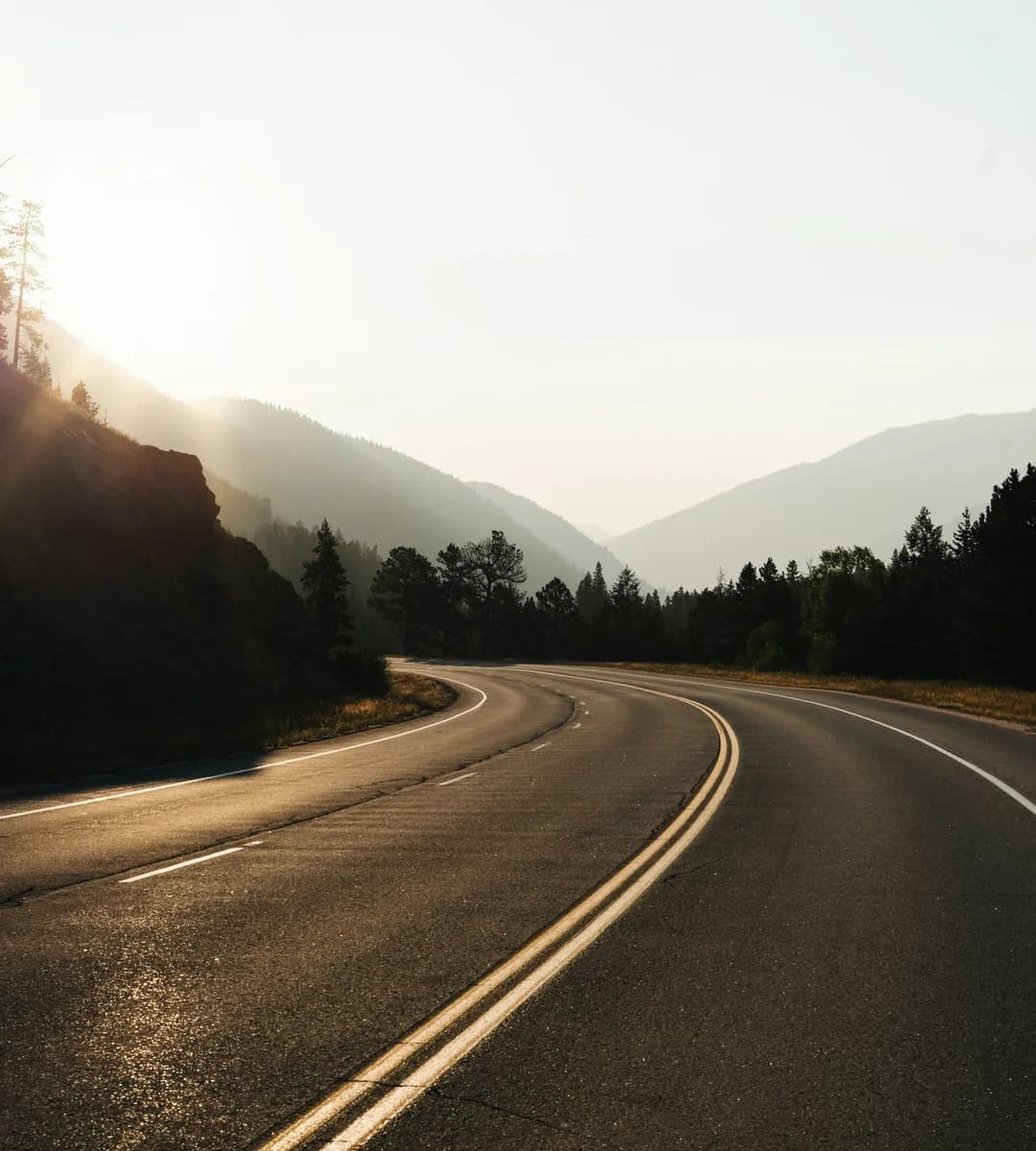 Photo by Holden Baxter on Unsplash Empty road with mountains at sunset